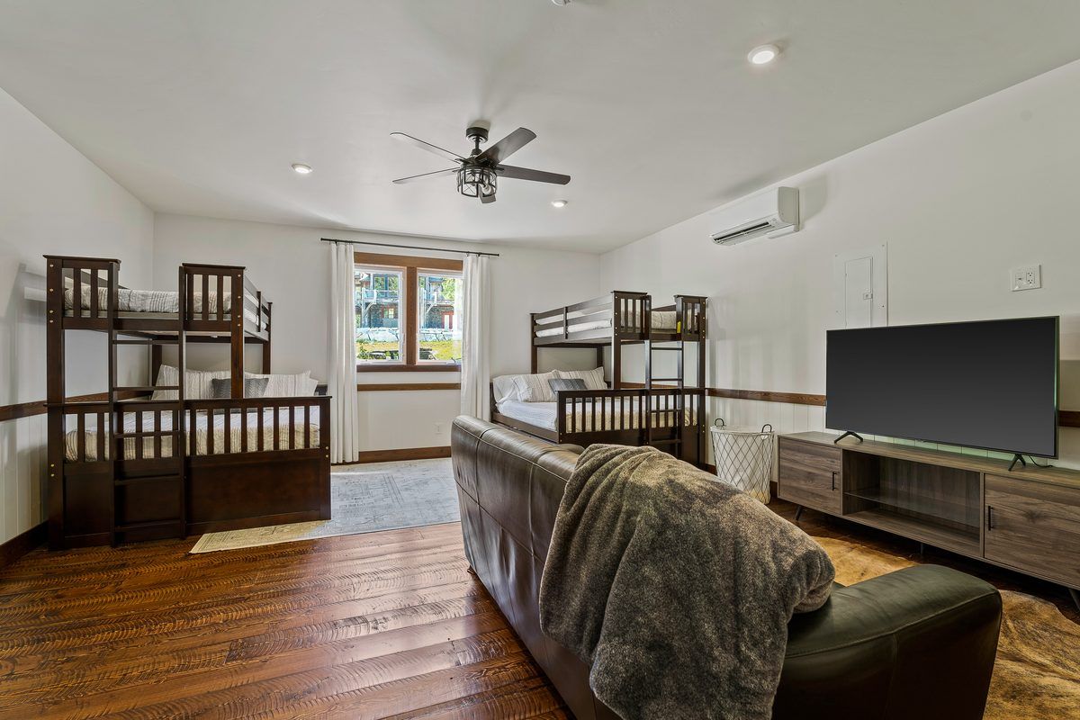 Bunk room with TV and sofa