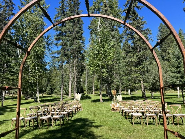 Rows of wooden chairs on the greenbelt, seen through a metal arch