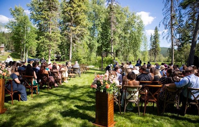 A summer ceremony on the lawn, guests seated among the aspens